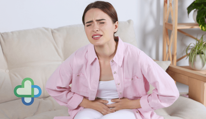 woman with a uti curled over holding her stomach - buy UTI treatment